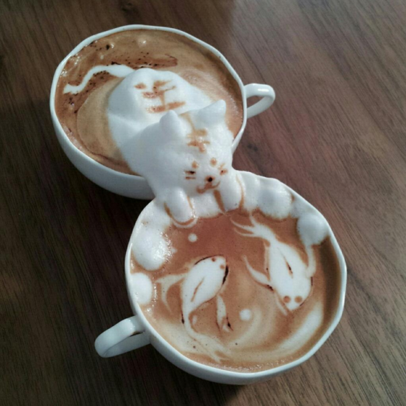 this-cute-design-has-a-cat-reaching-over-to-another-coffee-cup-to-watch-fish-swimming-in-the-coffee