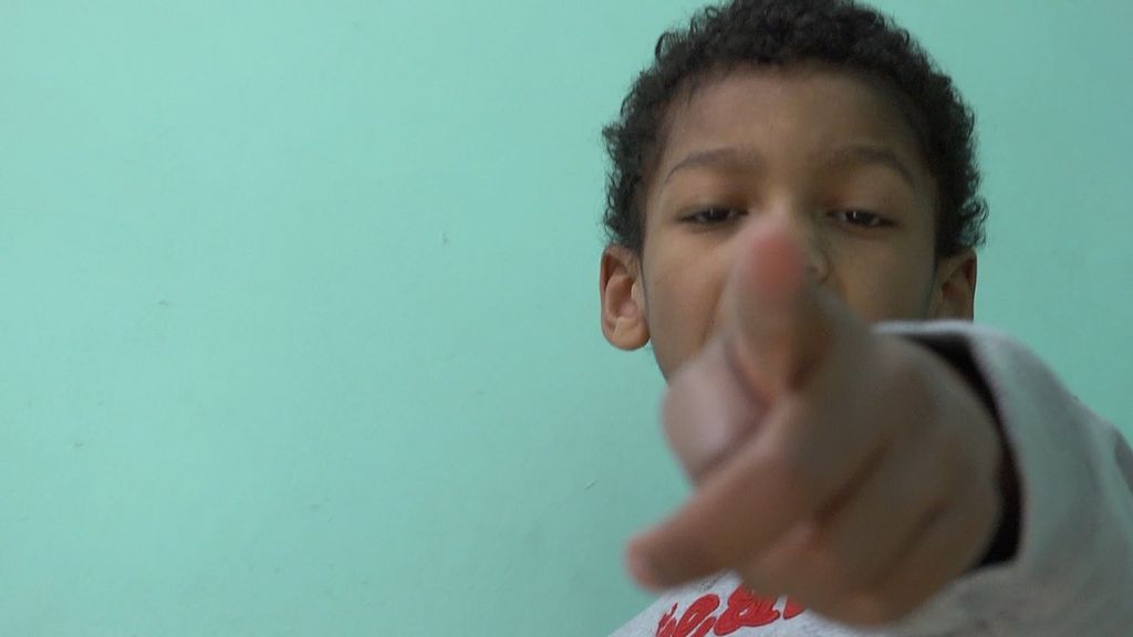 KID AGAINST TURQUOISE WALL